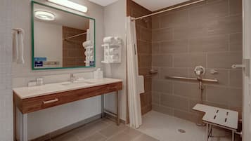 A modern bathroom with a vanity, a shower, and a glass-enclosed shower stall.