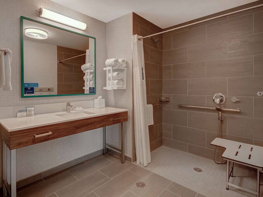 A modern bathroom with a vanity, a shower, and a glass-enclosed shower stall.