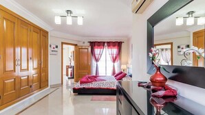 Una habitación de hotel con cama, cómoda, espejo y armario.