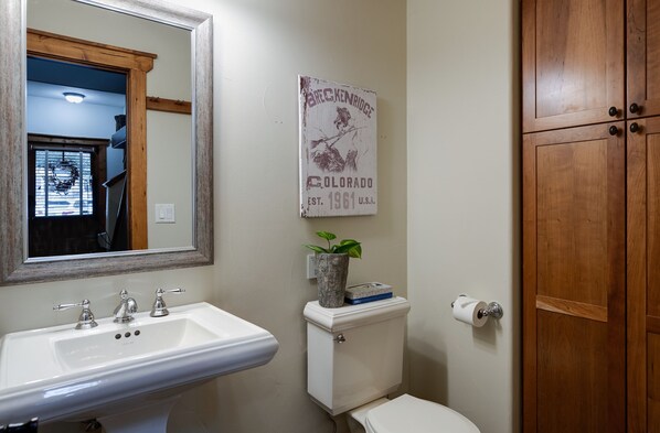 Un baño con un lavabo blanco, un inodoro y un armario de madera.