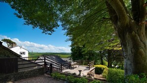 A rural property with a stone wall, a wooden gate, and a pathway leading to a white building with a chimney. - A luxury rural retreat, Barnstaple, perfect for couples and families, set in glorious North Devon (Barnstaple)