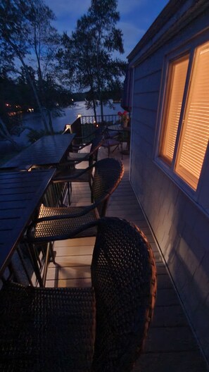 Relax on the lakeside deck with wicker chairs and a table, offering a serene atmosphere.