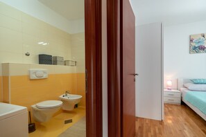 A bathroom with a toilet, bidet, and sink. - Modern apt w. Terrace, 2 min Walk to the Beach (Okrug)