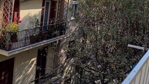 A multi-story residential building with balconies, a white awning, and a tree in the foreground. - Flat 66 (Thessaloniki)
