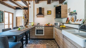 Une cuisine moderne avec des poutres en bois, un îlot central et divers appareils électroménagers.
