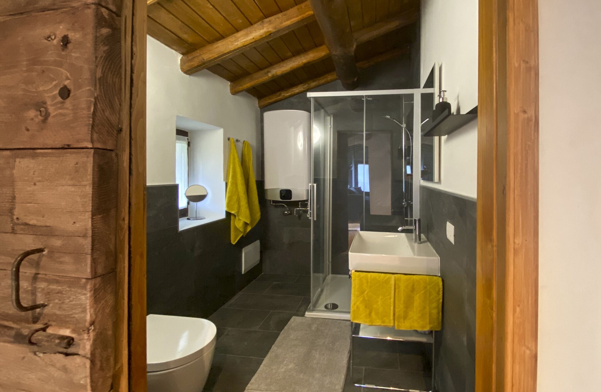 A modern bathroom with a shower, toilet, and sink.
