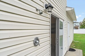 Fachada de una casa con revestimiento, una puerta, una ventana, un timbre y un buzón.