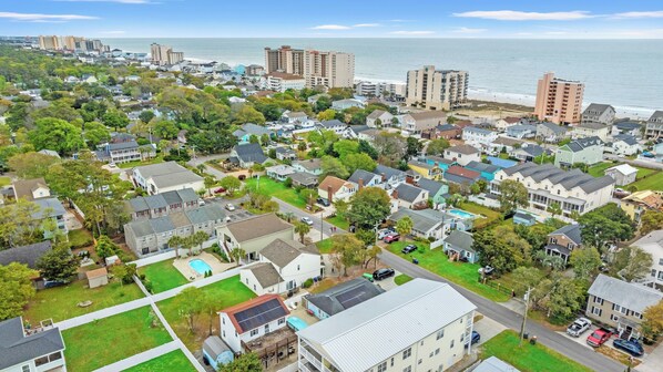 Un área residencial con casas, piscina y una playa al fondo.