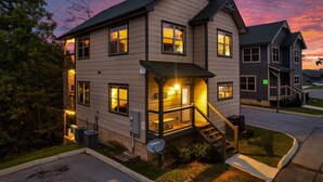 A two-story house with a front porch and a staircase leading to the entrance. - Private Indoor Pool Cabin | Arcade, Hot Tub | 1.5mi to Parkway (Pigeon Forge)
