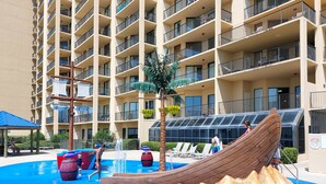 A multi-story hotel with balconies, a pool area with water features, and a slide. - Best Splash Pad in town 2/2 sleeps 8 Phoenix V813 (Orange Beach)