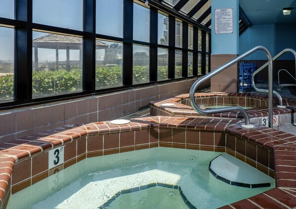 A swimming pool with a tiled edge, a number '3' indicating depth, and a view of greenery outside through large windows.