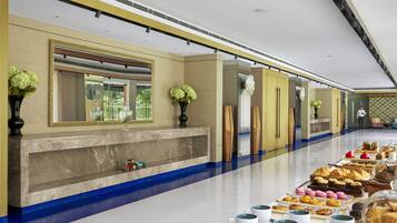 A long buffet table with various pastries and beverages.