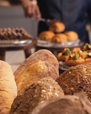 Diverse broden en gebak, waarschijnlijk in een bakkerij of tijdens een catering evenement.