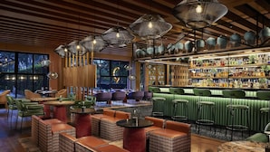 Een bar met zitplaatsen, een bar en diverse flessen.