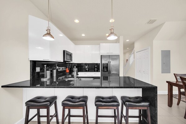 Enjoy cooking in this kitchen with a sleek island, stainless steel sink, and microwave.