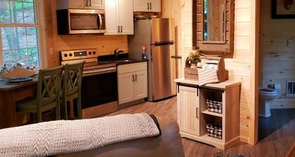 The Chalet is located in the woods of a gated property with a covered porch.