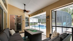 A spacious living area with a large window overlooking a backyard, a pool, and a ceiling fan. - HEATED PRIVATE POOL | CLOSE TO RAINBOW RIVER, CRYSTAL RIVER & GOLFING (Citrus Springs)