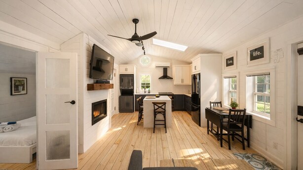 A modern kitchen with a central island, built-in appliances, and a ceiling fan. - The Cambridge Cove! Hot tub & Outdoor Gas Firepit (Fort Erie)