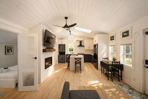 A modern kitchen with a central island, built-in appliances, and a ceiling fan.