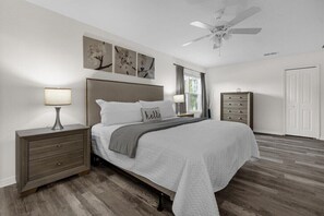 Relax in a serene bedroom with a large bed, bedside tables, and ceiling fan.