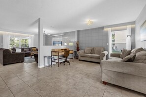 Relax in this serene living space with a sofa set, desk, and natural views.