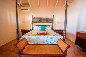 A bedroom with a bed, two nightstands, a wooden bench, and a ceiling fan. - Modern home, w/ pool & 2-mins to beach! (Christiansted)