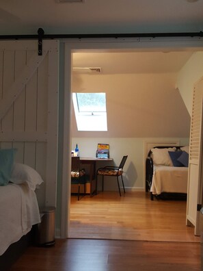 A bedroom with a bed, a desk with a chair, a window, and a trash can. - Dog friendly, Clean Studio with Separate Entrance 2.4 miles to Beach (Cotuit)