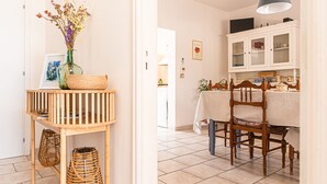 Un coin repas comprenant une table en bois, des chaises et un buffet blanc aux portes vitrées.