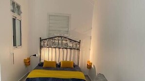 A bedroom with a bed, bedside tables, and a sofa. - Love Nest in the heart of the forest (Petit Bourg)