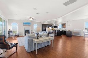 A spacious living room with a sofa, a coffee table, and a fireplace. - 🌊4BR Villa del Mar | Pet Friendly | Beautiful Ocean View | Walk to the Beach🌊 (New Smyrna Beach)