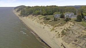 A coastal property with a large house and a beach. - Custom Lake Michigan Beachfront Vacation Home (Manistee)