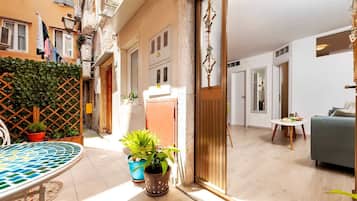 Un appartement moderne doté d’un patio carrelé, d’un coin repas et d’un salon avec un canapé.