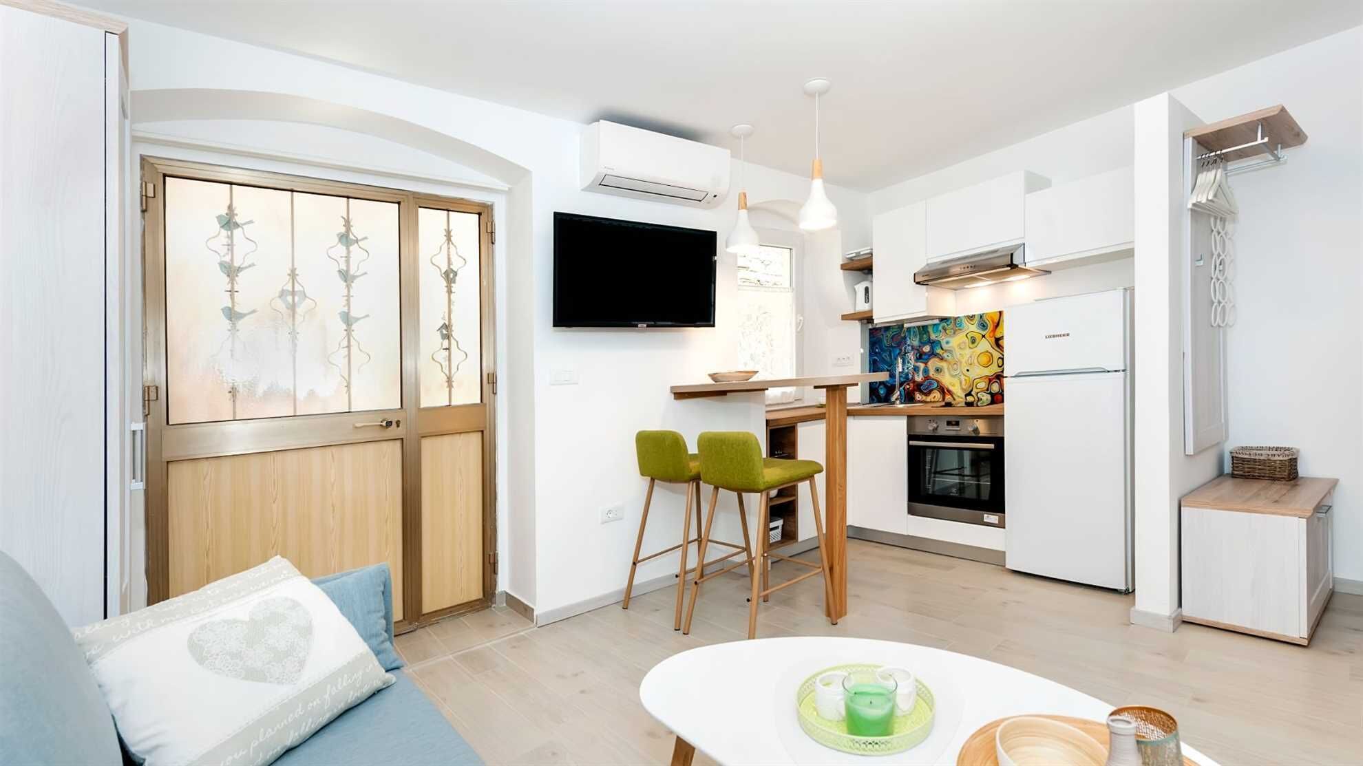 A modern apartment with a dining area, kitchen, and living room.