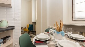 A dining area with a table set for four, including plates, glasses, and cutlery.