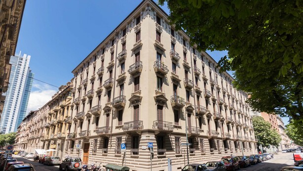 A multi-story building with a classic architectural style, featuring balconies and a central entrance.