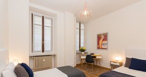 Una habitación de hotel moderna con dos camas, un escritorio y una silla.