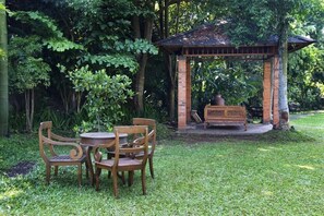 Relax in a serene garden setting, surrounded by lush greenery and a tranquil atmosphere.