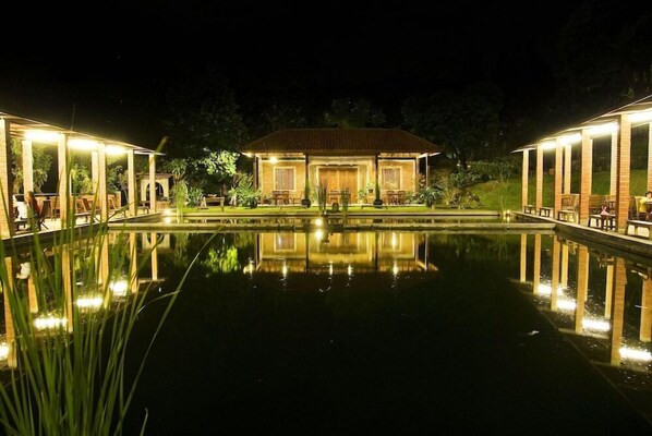 Stunning hotel architecture reflects off a serene water body, creating a tranquil ambiance.