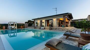 Relax by the rectangular pool surrounded by a tiled deck and lounge chairs.