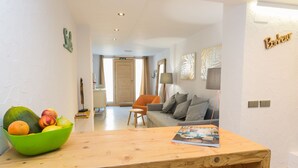 Una sala de estar moderna con una mesa de madera, un sofá y un cuenco con fruta.