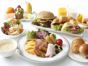 A breakfast buffet with various dishes including eggs, bacon, croissants, and fresh fruits. - Rhino (Kyoto)