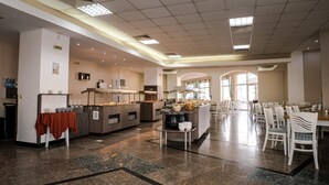 A spacious dining area with multiple buffet stations, white chairs, and a clean, modern design. - Villa Aurora (Varna)