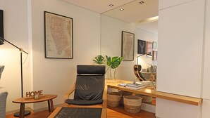 A modern living room with a black leather chair, a wooden coffee table, and a map on the wall. - FLH Sá da Bandeira Modern Apartment (Oporto)