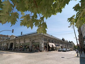 A historic building with classical architecture, a cobblestone street, and pedestrians.