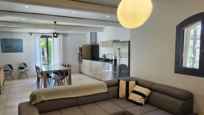 A modern living room with a sectional sofa, a wooden coffee table, and pendant lighting.