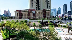 A hotel with a pool area, surrounded by greenery and palm trees. - MGM Signature Balcony Suite 2817 NO RESORT FEE (Las Vegas)