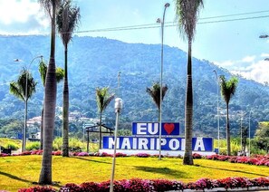 A sign with "EU NAIROPA" and a heart symbol, surrounded by palm trees and flowers, with a mountainous background. - Mezzanine!!! Grill, pizza oven, wood-fired oven, swimming pool. (SP)