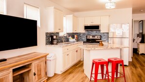 A modern kitchen with white cabinets, a black microwave, a stainless steel refrigerator, and a wooden countertop. - Beach Condo & Pool Relaxing Getaway! Short Stride to Sandy Beach's. Unit 8 (Panama City Beach)