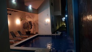 Un espace piscine avec des chaises longues et une plante en pot.