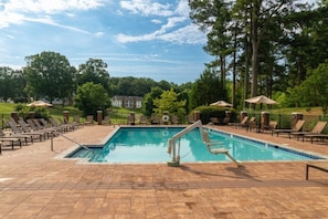 Relax by the clear pool surrounded by lounge chairs and umbrellas.